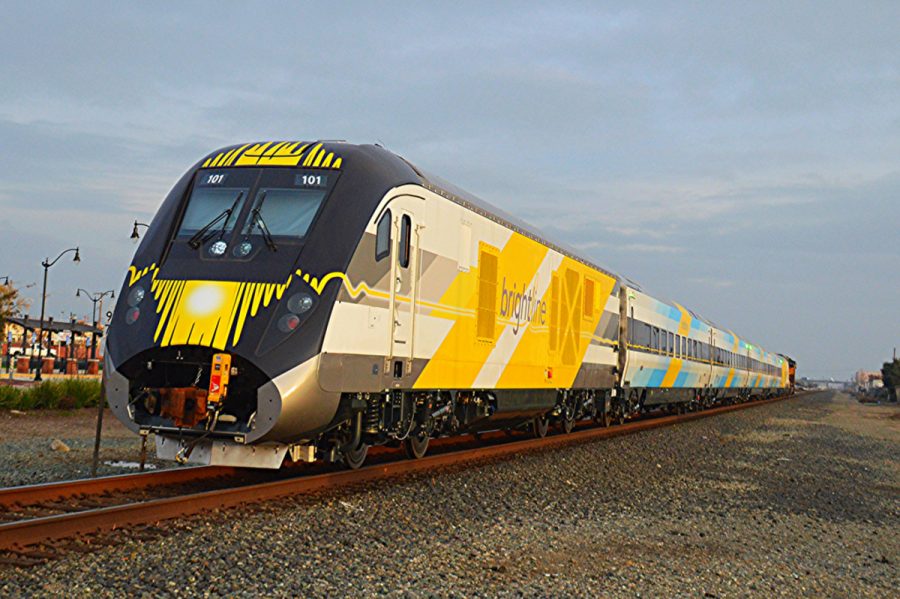 Brightline’s blue train set rolls down the track, the first of several other Siemens Charger diesel locomotive and passenger coaches that will be part of the company’s fleet, which currently operates 20 daily trips. 