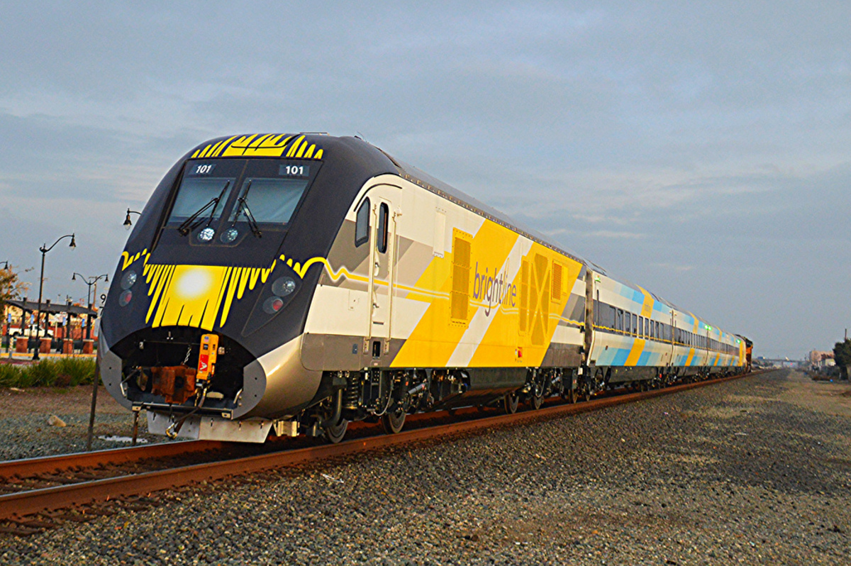 Brightline’s blue train set rolls down the track, the first of several other Siemens Charger diesel locomotive and passenger coaches that will be part of the company’s fleet, which currently operates 20 daily trips.