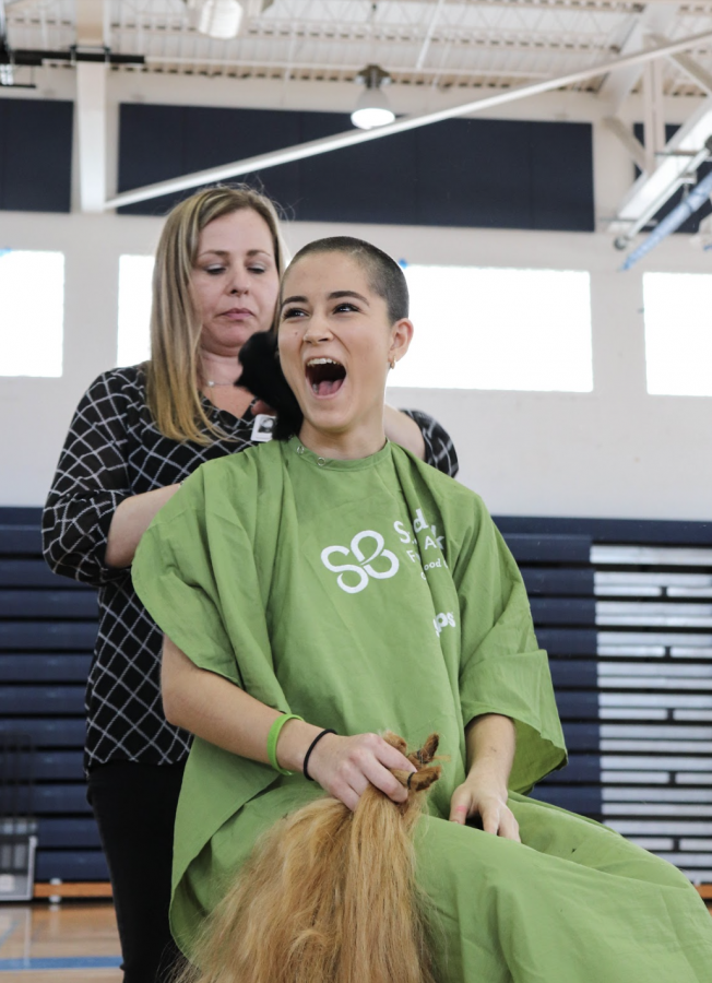 Communications sophomore Milani Gosman shaves her head in support of the St. Baldrick’s Foundation. “I know that [through St. Baldrick’s], I’m not only donating my hair but I’m donating money,” Gosman said. “It’s such a good environment, they’re so nice and the company was so easy to work with it was a great experience.” Gosman was one of 10 students who shaved their heads at the event. 