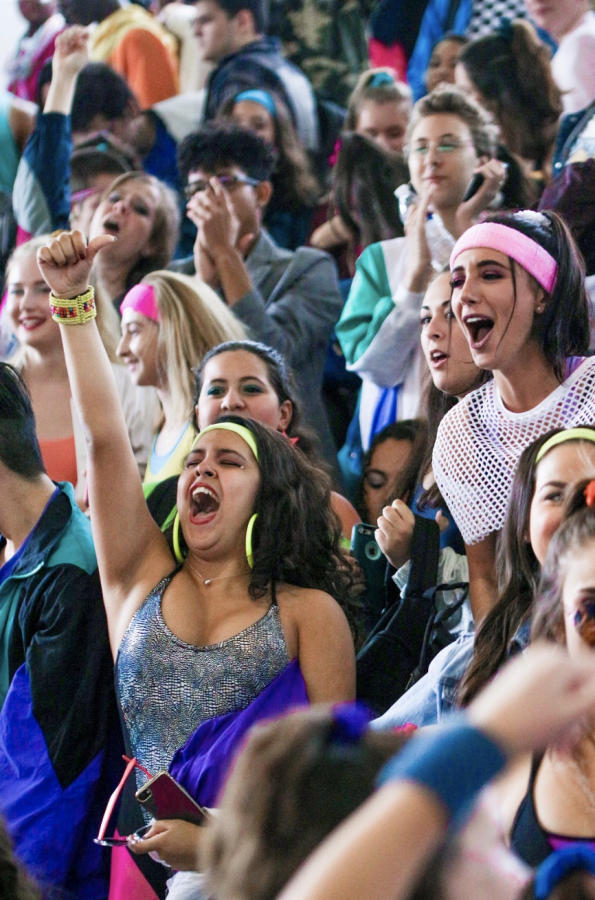 Dressed in neon 80s workout gear, dance senior Carolina Guerrero cheers along with the senior class after they are announced winners of the Generation Day dances. The seniors celebrated in the stands over their victory which would increase their overall point count for the week, keeping them in first place. 