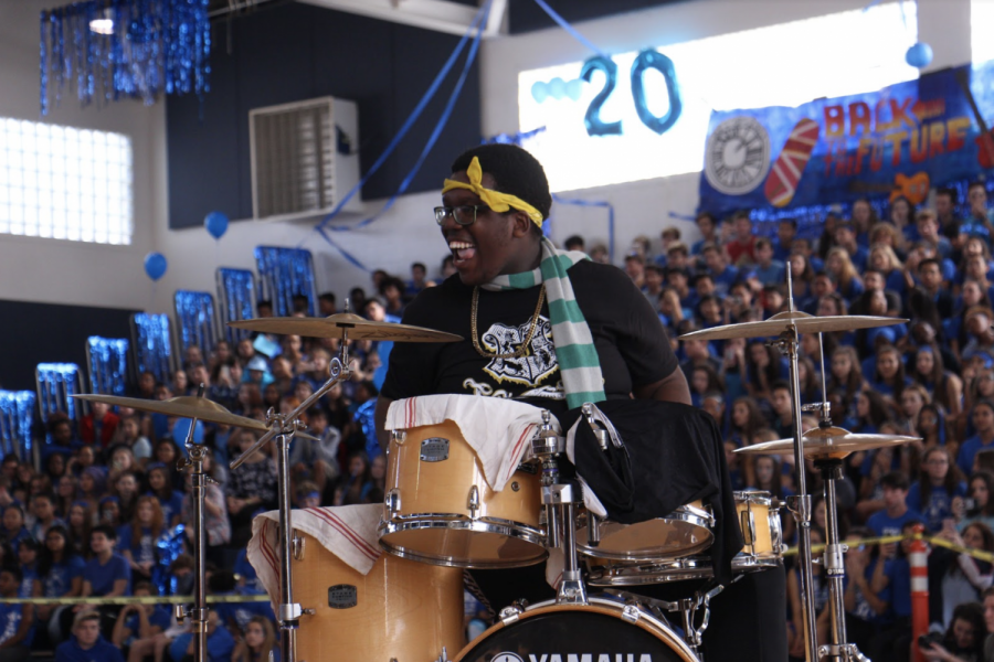 Strings senior Allen Cadet plays drums during the pep rally karaoke competition.