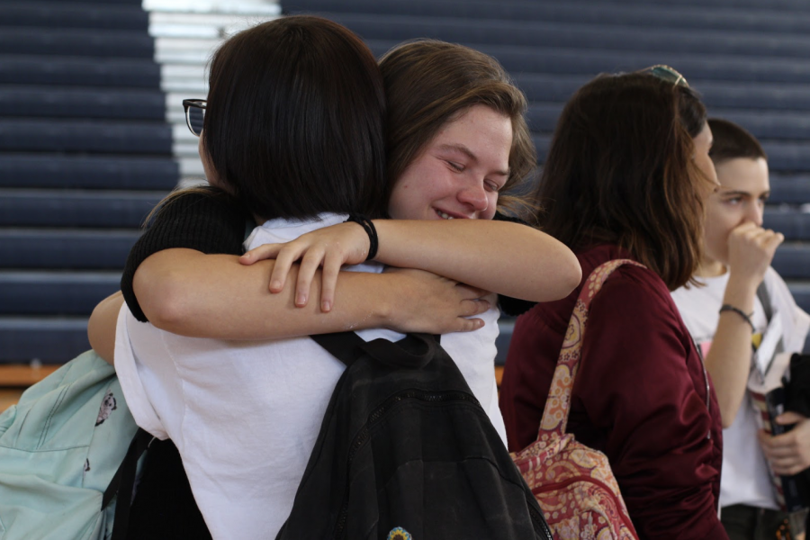 Digital media sophomore Dani Walters embraces a fellow student following the memorial ceremony for the victims of the Marjory Stoneman Douglas High School shooting in the gym during lunch. “There are a lot of people who are very sad about this, and we need to unite, and that’s what [the memorial] is for,” dance senior Lauren Clair said. Many students stayed behind in the gym after the performances and presentations to sign a poster that will be given to the students of Stoneman Douglas, learn about donating their prom dresses to students affected by the massacre, and to gather refreshments. 