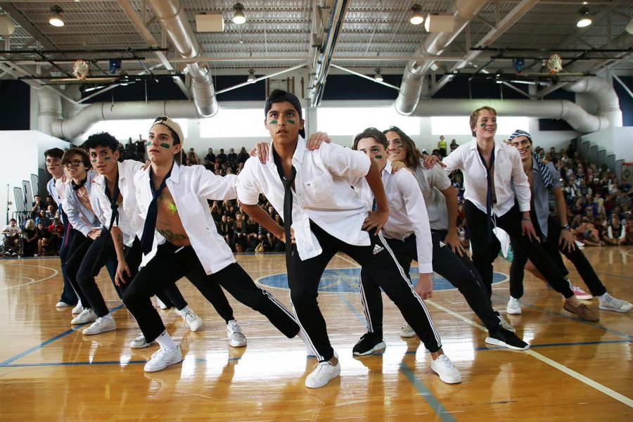 Visual sophomore Sergio Aries guides his fellow “cheerleaders” into the next dance move, as the crowd cheers them on. The sophomores placed third overall in the powderpuff cheerleading competition. 