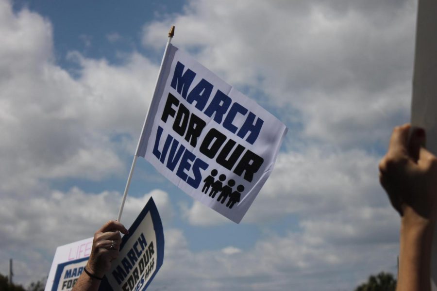 An activist at the West Palm Beach March for Our Lives stands alongside thousands of others, all with signs and flags to call attention to the excessive gun violence in the U.S. Students behind the Never Again movement were able to raise millions of dollars, and used the donations to organize events worldwide. Flags like the one pictured above could be purchased at the march, and all funds were to support the cause.
