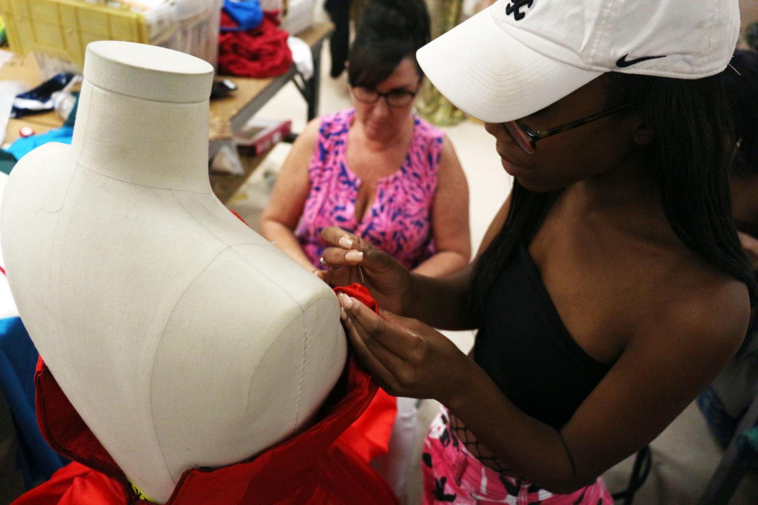 Theatre artist in residence Penny Koleos-Williams assists theatre senior Skylar Anthony with a project during her costuming class.