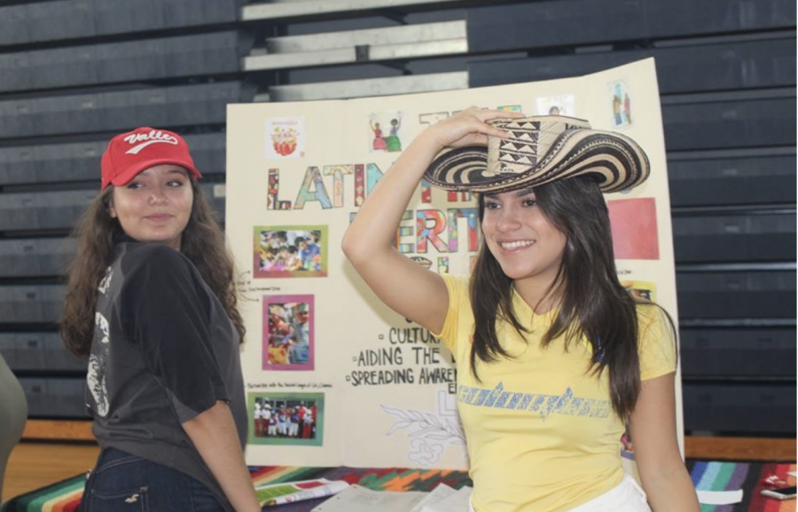 Communications junior and Latin Hispanic Heritage Club President Catalina Correa stands with vocal junior Diana Parra at their table during the 2017 Club Rush. The aim of the club is to provide space for those with Hispanic or Latin heritage to meet and share their experiences. “It allows people to see that Dreyfoos actually is a diverse place,” Correa said. “It also lets Latino students know that they're not alone.” 

