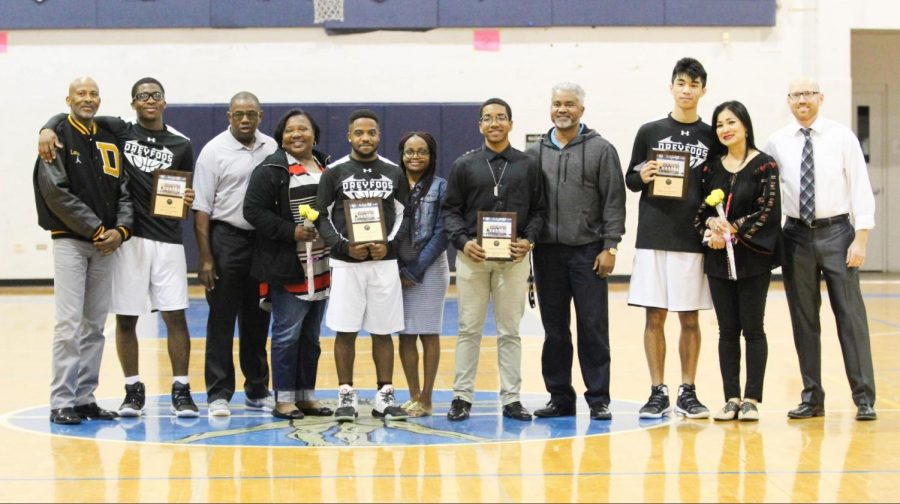 (Players from left to right: visual senior Lance Carter, vocal senior Jaylen Thompson, visual senior Nickolas Pressoir, and strings senior Alan Le) The seniors of the basketball team stand with parents at their last home game of the year on Jan. 24. Basketball coach and math teacher Matthew Vaughan (far right) smiles as he looks back on the growth of the team this season. “This is my first year coaching [the basketball team], so I had to earn their trust. But after our first win, things started to click with the team,” Vaughan said. “Every time we played [a team] for the second time this year, we have come back and done leaps and bounds better.”