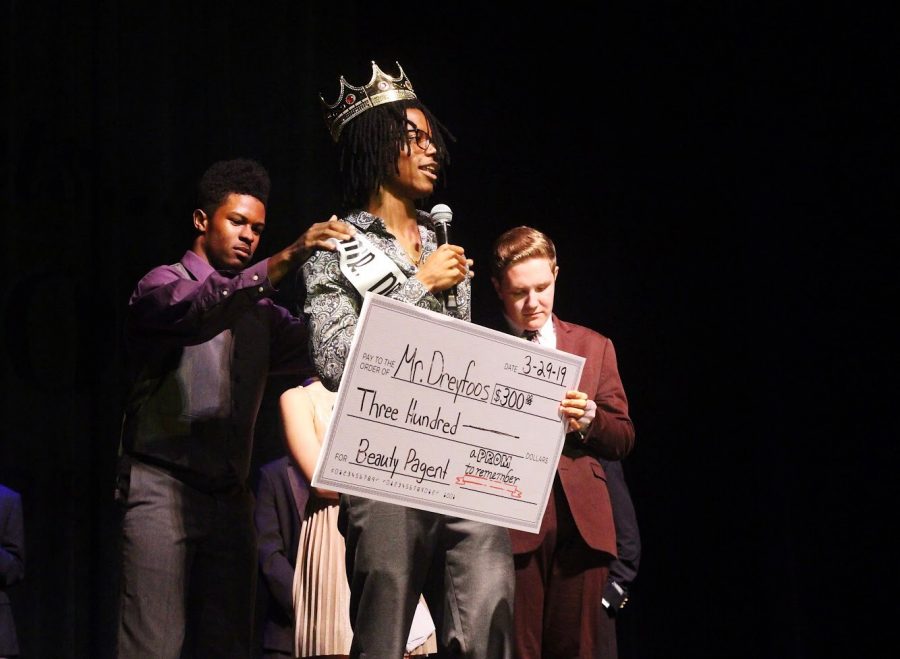 Visual senior Njari Anderson receives a check for $300 as he gets crowned the next Mr. Dreyfoos. Anderson expressed how he “can’t thank everyone enough” as he posed in his crown and sash for the audience.