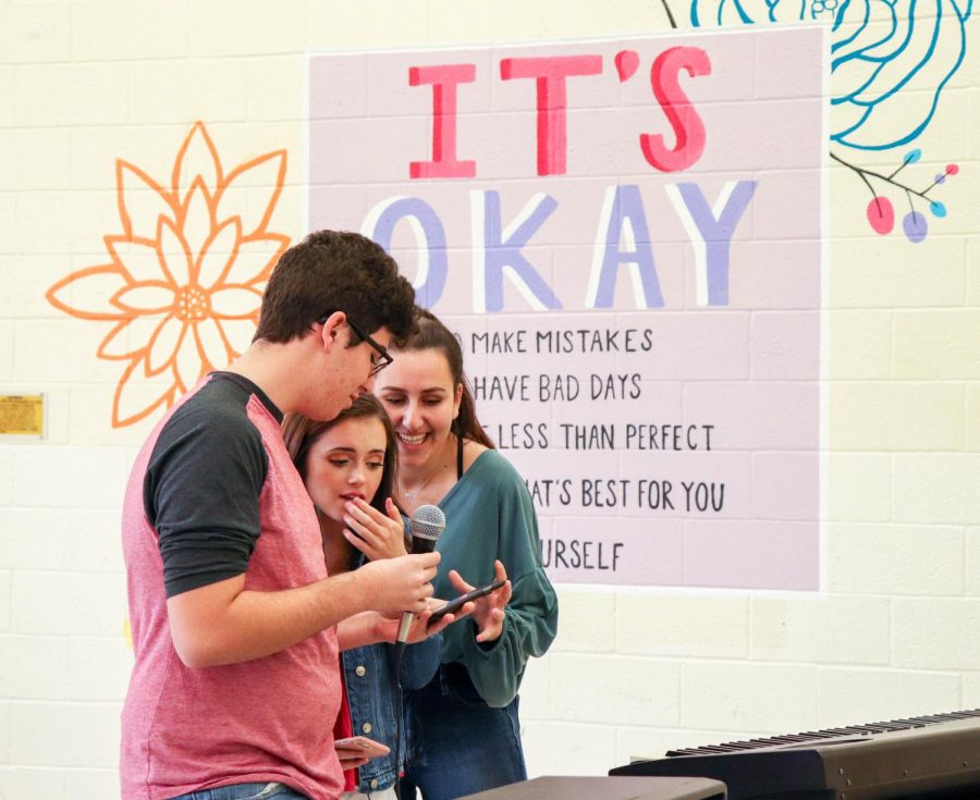 Communications juniors Katherine McNamara and Sebastian Fernandez prepare to speak as they stand in front of the new mural in the cafeteria designed by visual juniors Angel Ly and Amanda Cohen. “It was a big collection of organizations that helped us put it on, but also lots of individual people,” Fernandez said. “We couldnt have made the week as good as it was without the help of the community.”