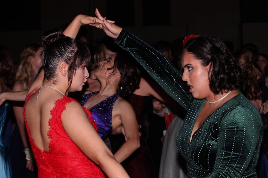 Visual senior Lily Moore and digital media senior Laura Cruz dance, wearing colorful dresses. Prom, thrown for the juniors and seniors, was held at the Palm Beach County Convention Center.