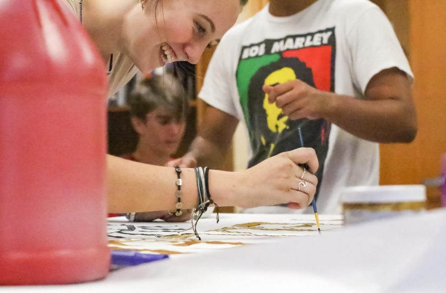 Communications junior Lucy Steigenga paints a sign for the haunted house while staying after school on Oct. 14. The theme revolves around humans in animal masks harvesting organs from other humans, thus inspiring the name The Harvest. 