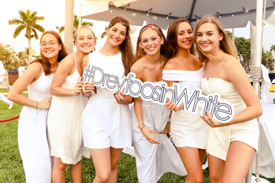 Dance majors pose with a Dreyfoos in White sign before leading guests to their tables, where they enjoyed dinner and drinks before the dancing and raffles started. 