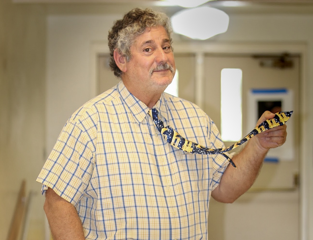 Known for his quirky ties, assistant principal George Miller holds one adorned with trumpets and music notes, just one of many of his musical ties. Over the past several years, Mr. Miller has been giving his eccentric ties away to students who compliment them. “I think the kids appreciate it when I give them one of my ties,” Mr. Miller said. “If a kid likes it and you give it to them, they’re happy.”