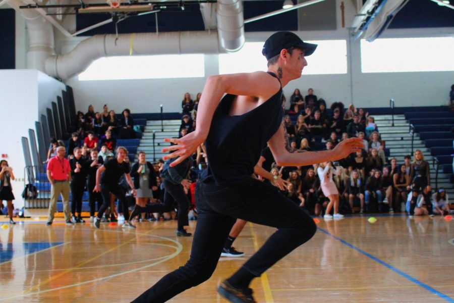 Strings senior Justin Toterella runs to scoop up the dodgeballs sitting in the center of the gym. Dressed completely in black, Toterella fit right in with the rest of his team members, who also wore black for the seniors’ goth theme.