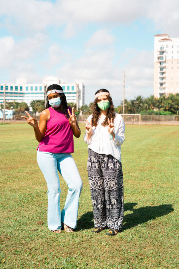 Teneisha Finney and Sarah Garcia display peace signs in true hippie spirit. The symbol was originally used as a “V” sign for victory by the Allied Nations in World War II, but was reclaimed by anti-war activists in the 1960s. Photo by Allison Robbert.