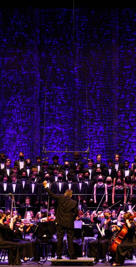 Band director Evan Rogovin throws his fist in the air as the closing piece, “When You Believe,” finishes, marking the end of the concert.