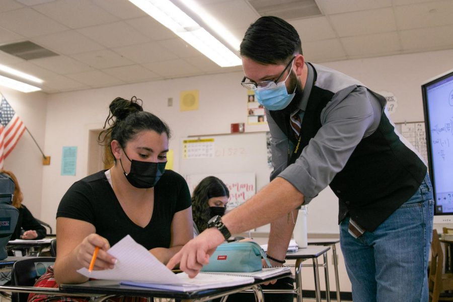 New math teacher Timothy Freeman helps band sophomore Gianna “Gigi” Mendelson with homework problems at the end of his fifth period precalculus class. Her classmate, band sophomore Ryan Brown, believes Mr. Freeman’s spontaneous style of teaching better “accommodates the needs of the class” by going at the pace of the class. “If you have a more rigid system, you can’t be that flexible,” Brown said. “You can’t be that adaptable.”
