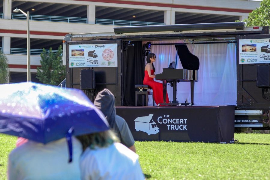 Guest pianist Susan Zhang plays on The Concert Truck for students and staff spread out across the field. 