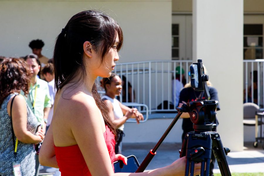 Zhang adjusts the tripod and camera to record her partner and co-director Nick Luby performing on The Concert Truck.