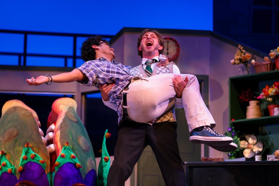 Mushnik lifts Seymour into his arms as they belt out the closing of “Mushnik and Son,” a song in which Mushnik decides to adopt Seymour to ensure he remains loyalty to the shop, maintaining the fame and glory he brought with the creation of Audrey II.