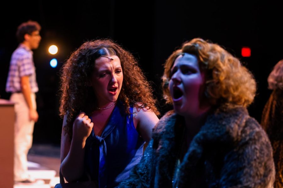 Theatre sophomore Nicolette Clivio looks toward theatre junior Maggie Bohanek as they sing the ensemble parts of “Skid Row (Downtown).”