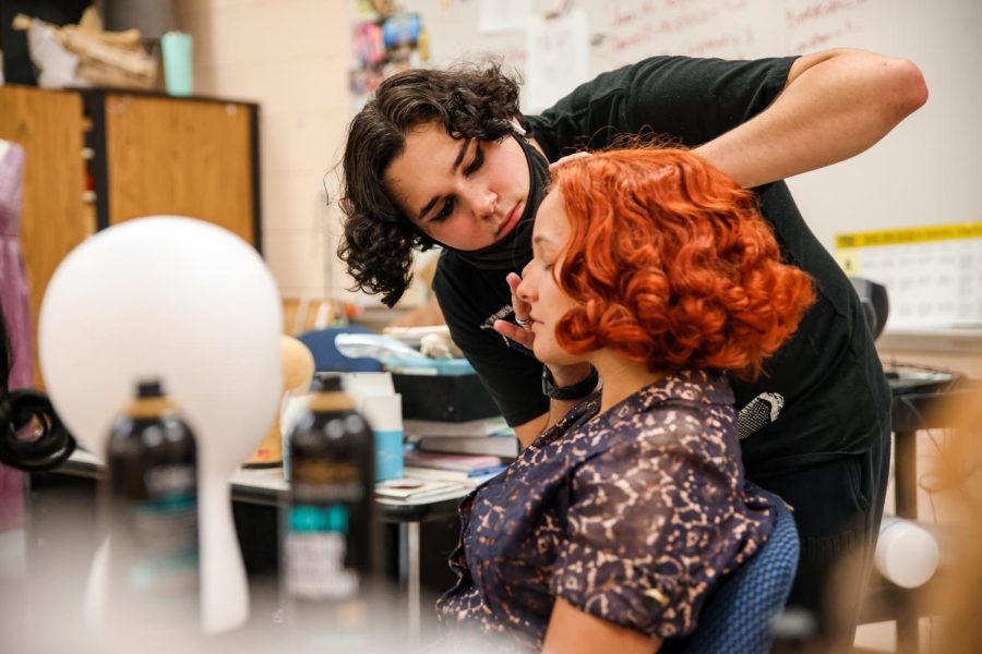 Hair and makeup head and theatre senior Hank Brown tests new looks on Whitacre after having styled the bright orange wig. Brown has worked on multiple hair and makeup crews for previous shows, including “Radium Girls” and “Crybaby,” though this is his first time getting to head one.
