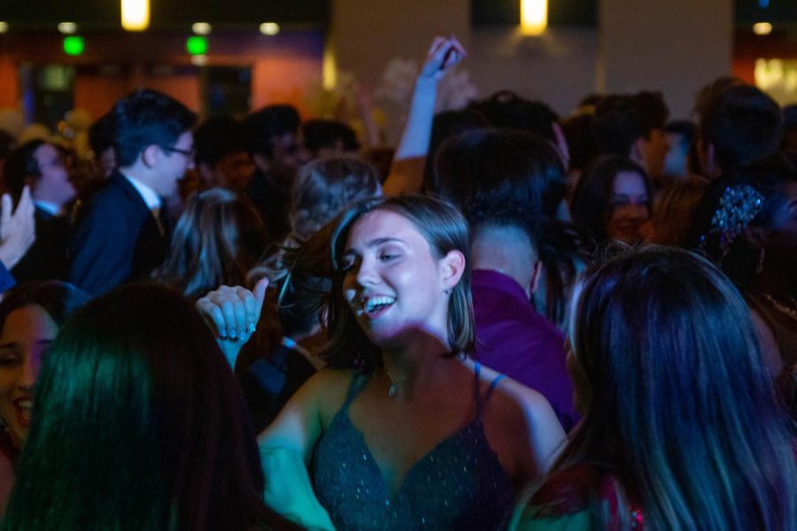 Vocal senior Lillian Critchett dances with friends, surrounded by others doing the same.