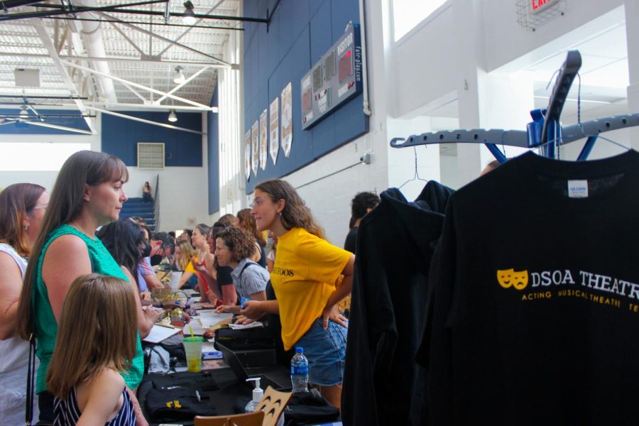 Theatre senior Brandi Quigley talks to the parents of new students about theatre merchandise being sold. While students were in Meyer Hall for their presentations, parents were able to meander through the gym and browse different booths from a variety of organizations and majors. They had the opportunity to sign up to be a part of the PTO, purchase school “swag,” as well as learn more about the publications.
