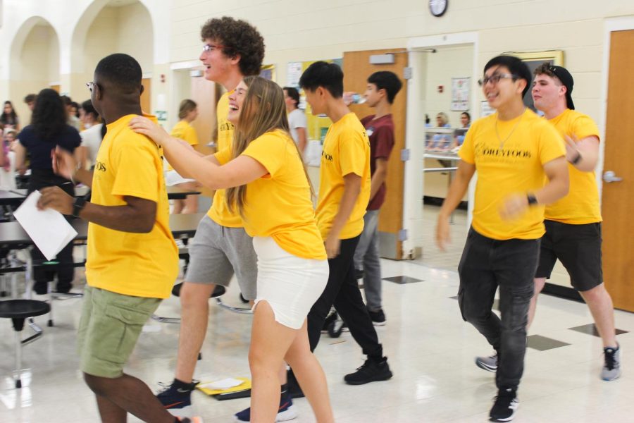 After an assembly overviewing school rules and school spirit, communications senior Kate Wagner laughs as she relaxes in the cafeteria with fellow volunteers and incoming students. Freshmen learned the chant specific to their graduating class so they would be prepared for this years pep rally. “As soon as we introduce that chant, you kind of feel the connection with your classmates, and that continues throughout the four years.” Wagner said. 
