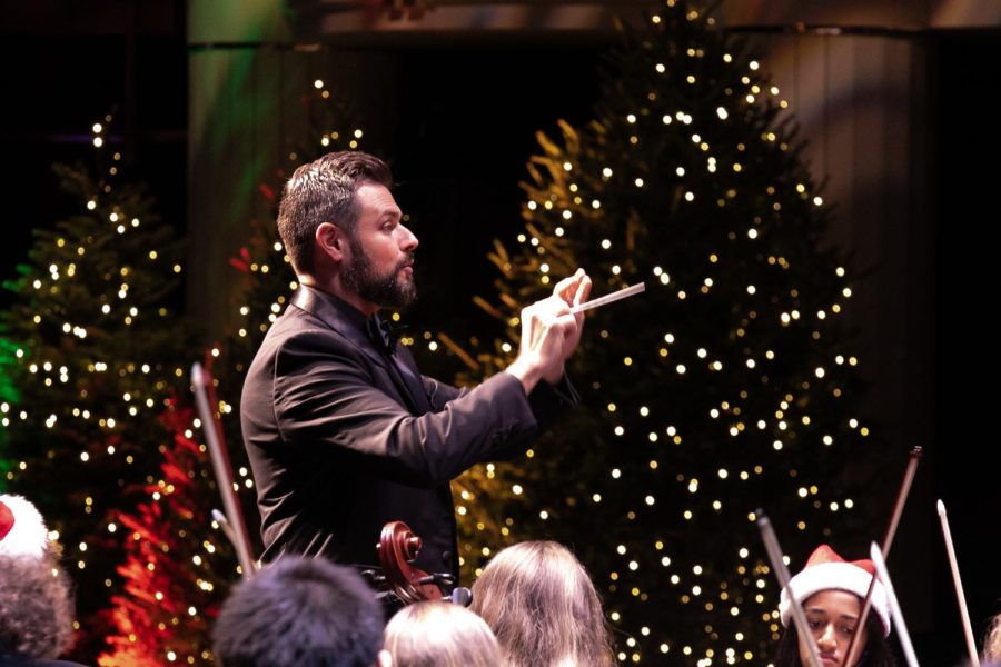 Conducting the orchestra, jazz director Christopher De León leads band and vocal students in the finale of the annual Prism concert, “Jingle Bells.” Music students performed an array of holiday songs at the Kravis Center in front of an audience of students from Dreyfoos and visiting middle and elementary schools.