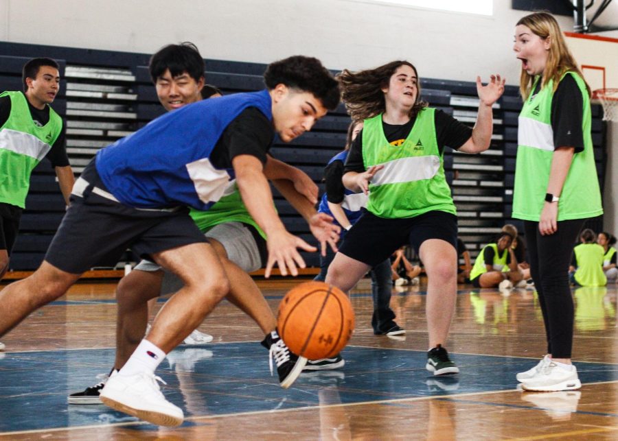 Steering the ball away from the opposing team, vocal junior Larry Perez plays offense during a scrimmage in his team sports class. 