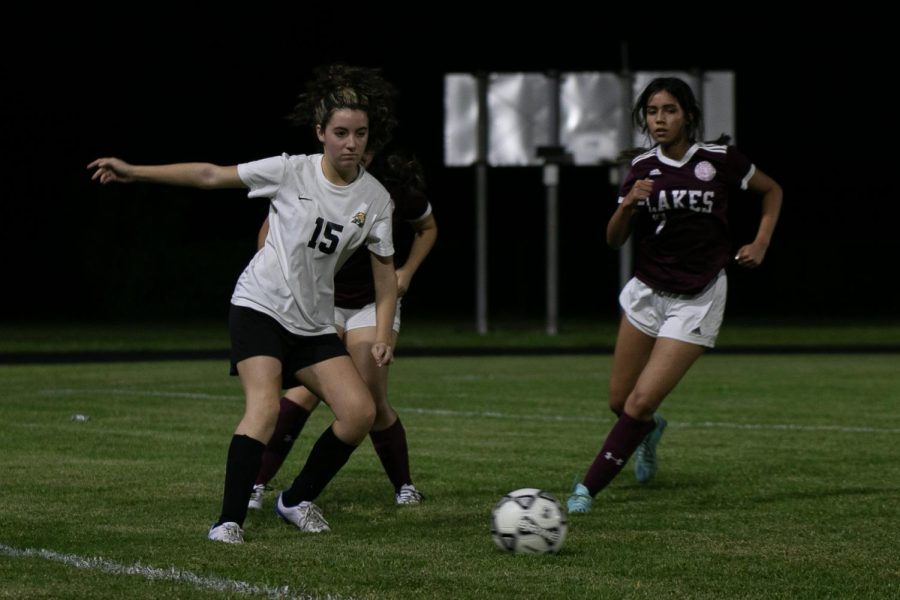 Blocking a Twin Lakes player, band senior Ava DeGaetano maneuvers herself to kick the ball. The girls soccer team won their match 7 - 0, continuing a winning streak. . 