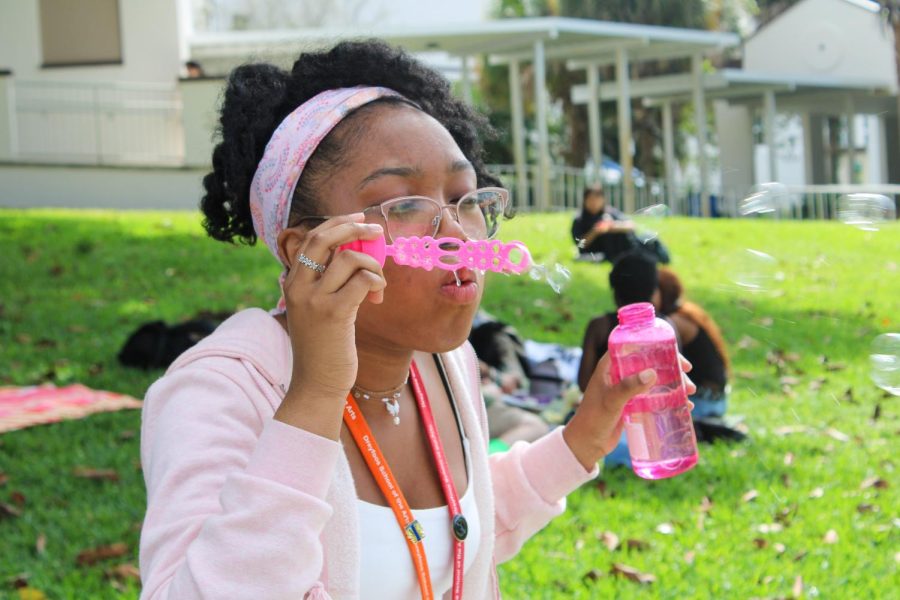 Blowing bubbles, theatre junior Mahogany Prichard celebrates during the BSU Unity Day picnic.
