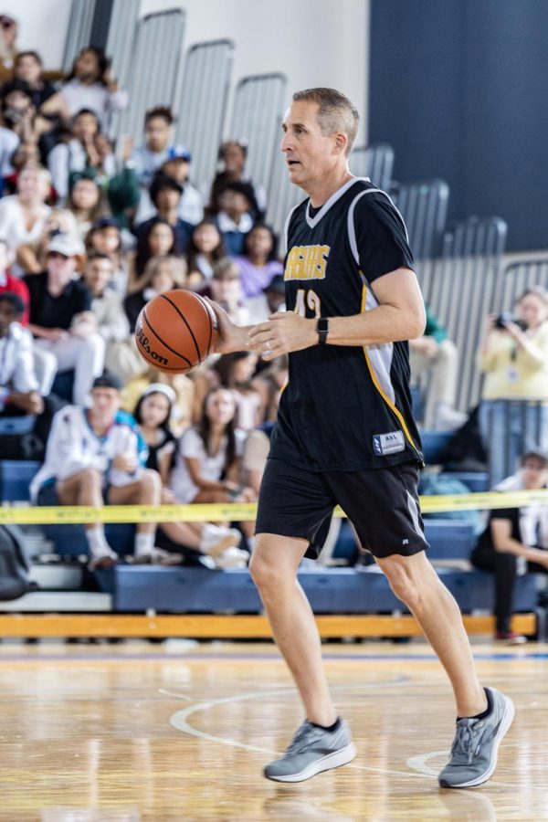 Dribbling the ball down the court, social studies teacher Jeffrey Stohr tries to score a point for the teacher team. 