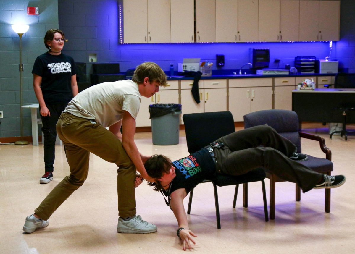 Theatre senior Lucas Lacey saves digital media senior Coral Johnston from falling out of her chair while reenacting a morning newscast.
