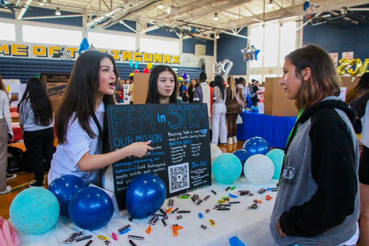 Pointing to her club poster, visual senior Albertina Abrate explains the Fem in STEM club. Club Rush, an annual tradition, took place on Tuesday, Sept. 12. This year, a total of 103 different club tables were set up, giving students the option to explore new opportunities.