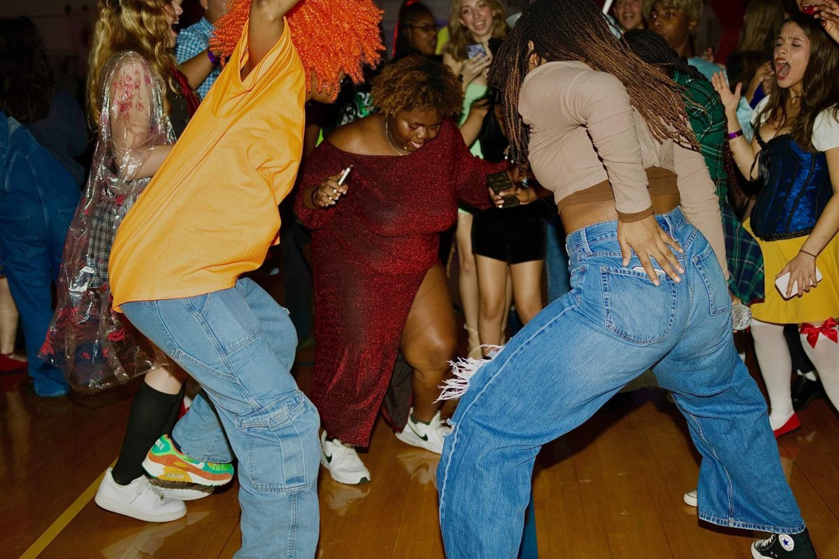 Dancing with friends, visual senior Cherise Hightower attends the Fall Dance. Students danced in the gym, walked through the haunted house in the media center, or attempted the escape room.