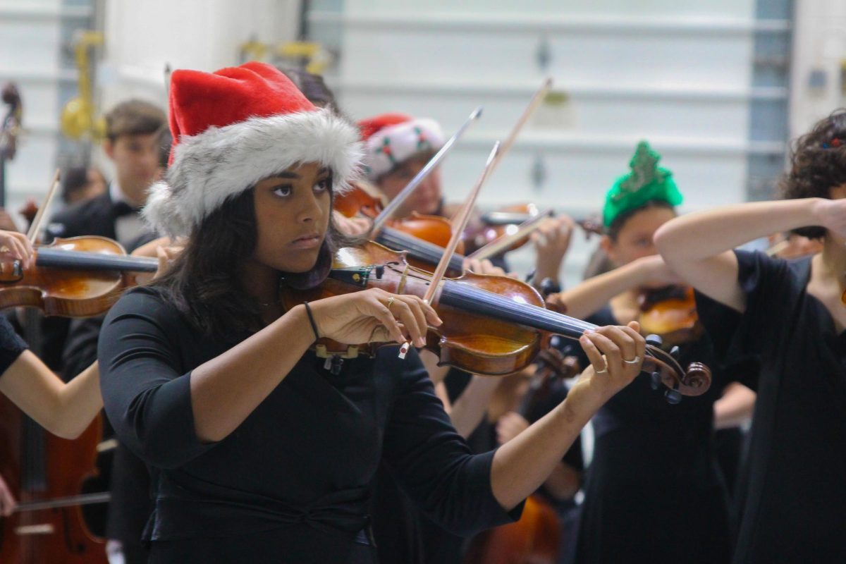 Strings sophomore Petra Dababneh practices with her bandmates in a backstage storage room before going onstage at the Prism dress rehearsal on Nov. 28. Before each song, performers gathered there to collect themselves and rehearse their music.