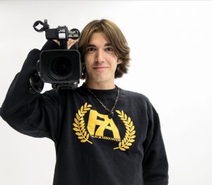 Communications senior Adin Darling poses with a video camera.