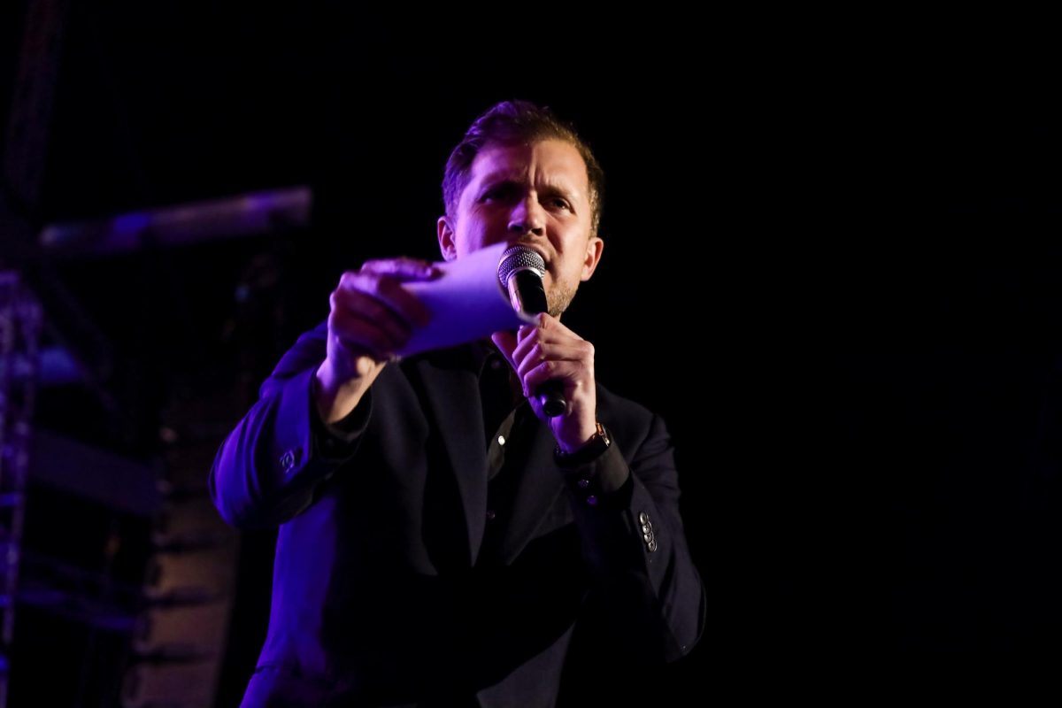 An auctioneer urges the crowd to outbid each other during the charity auction portion of the concert. 