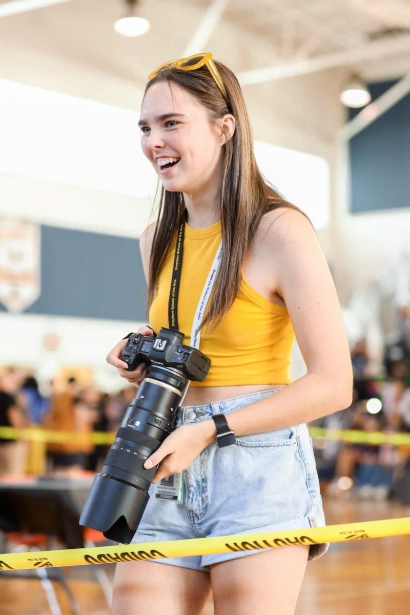 Former production managing editor on The Muse Lexi Critchett smiles, ready to photograph the 2022 Fall Festival. 