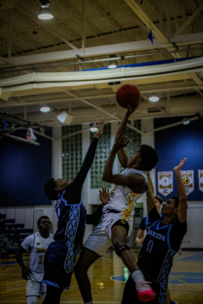 Pulling up for a jump shot, vocal senior Zidane Guerrier takes off from the ground over his opponents.     