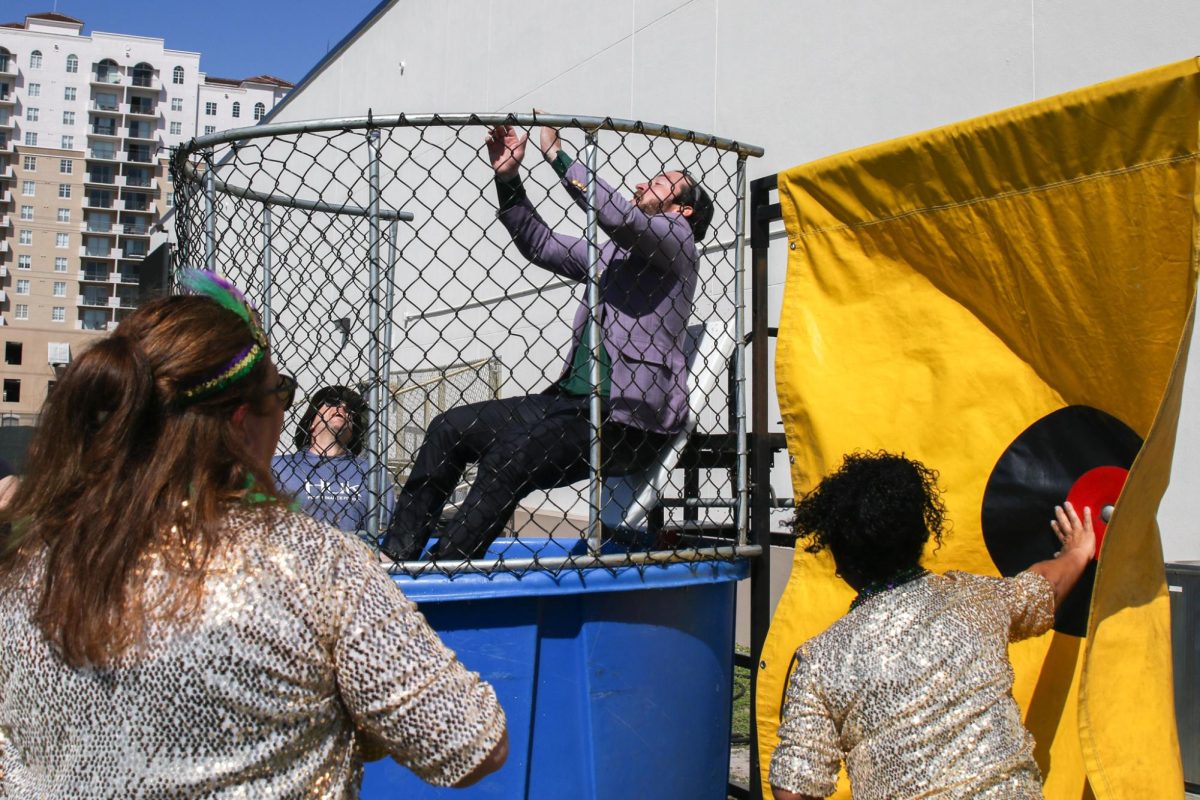 Slamming the dunk button, administrator Belinda Castillo drops math teacher Craig Adams into the water. The dunk tank was an SGA fundraiser, featuring several other teachers including social studies teacher Ross Vening and assistant principal William Clark.