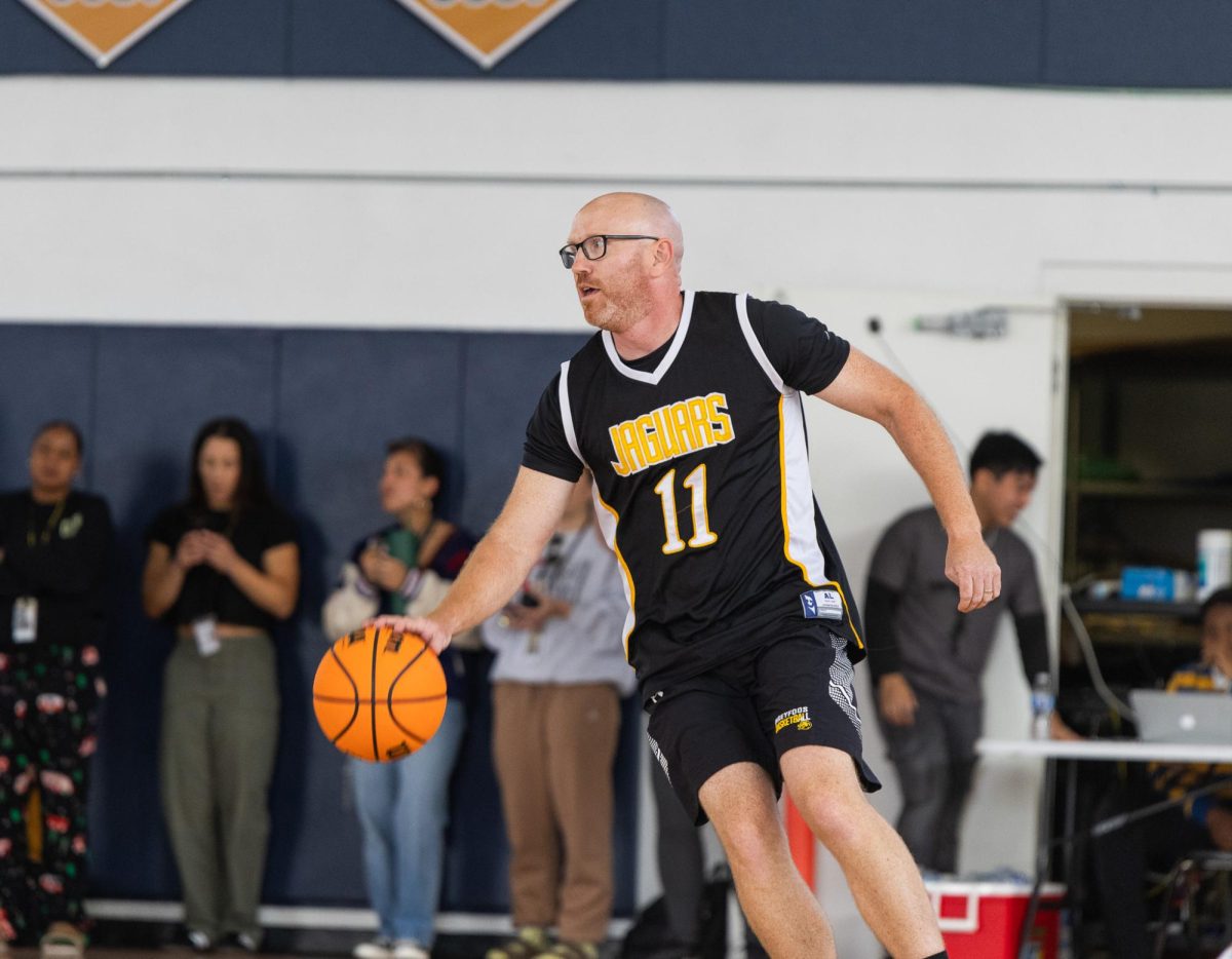 Coach and athletic director Matthew Vaughan dribbles the ball across the court as the crowd roars behind him. Coach Vaughan felt the teachers winning the game was a powerful moment not only to him but also to the school. “Its not really about winning (or) losing, even though we want to win. Its to make everybody happy. Were trying to participate and to show them that were real people too, not just robot teachers.” Vaughan said.