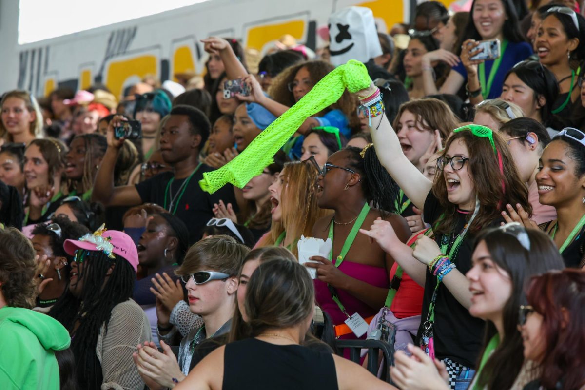 Lining the bleachers in the gymnasium, sophomores cheer on performers during the Battle of the Bands competition.