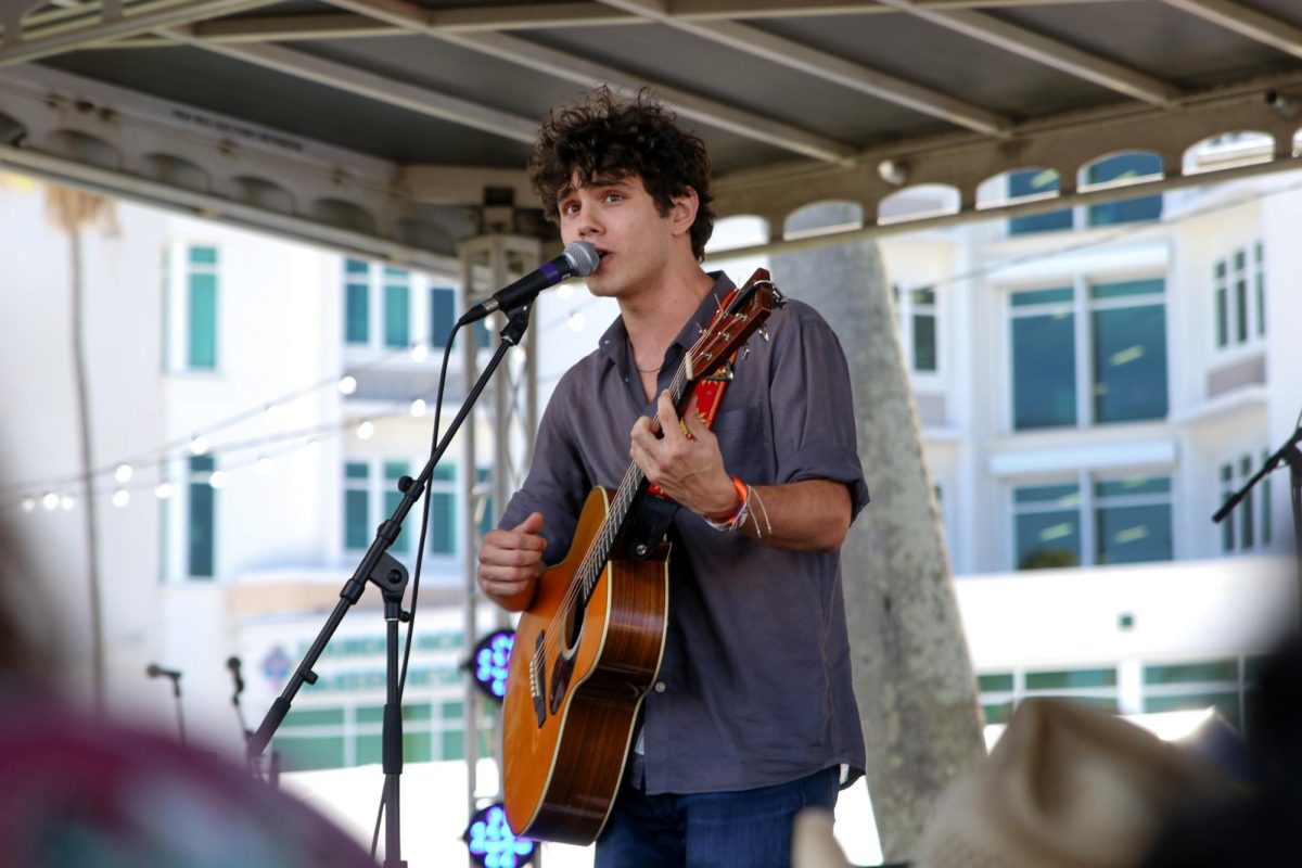 Looking towards the audience, Ben Krieger sing his original song “Burden On Me” during his set at Sunfest.
