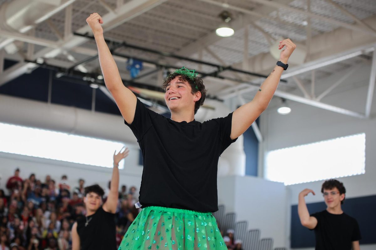 Cheering with his hands up, strings sophomore Carter Reese finishes his class’ Powderpuff dance routine. “It felt great,” Reese said. “I got to represent my class in a fun way and work with my friends.”