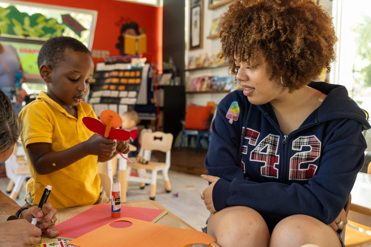 Interacting with a pre-school learner, Justice Builder intern and digital senior Aaliyah Keys helps lead the day’s craft activity centered around the letter “I.” As part of her paid internship at Rohi’s Readery, which focuses on community outreach and social justice education, Keys prepared pre-made craft pieces for the children to easily assemble an insect.