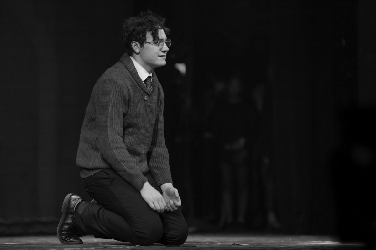 Kneeling on the stage, theatre senior Connor Hullender (Harry Potter), stares out toward the audience. This moment followed the scene where Potter, who travelled back in time to save his son, hears his parents get killed by Voldemort.