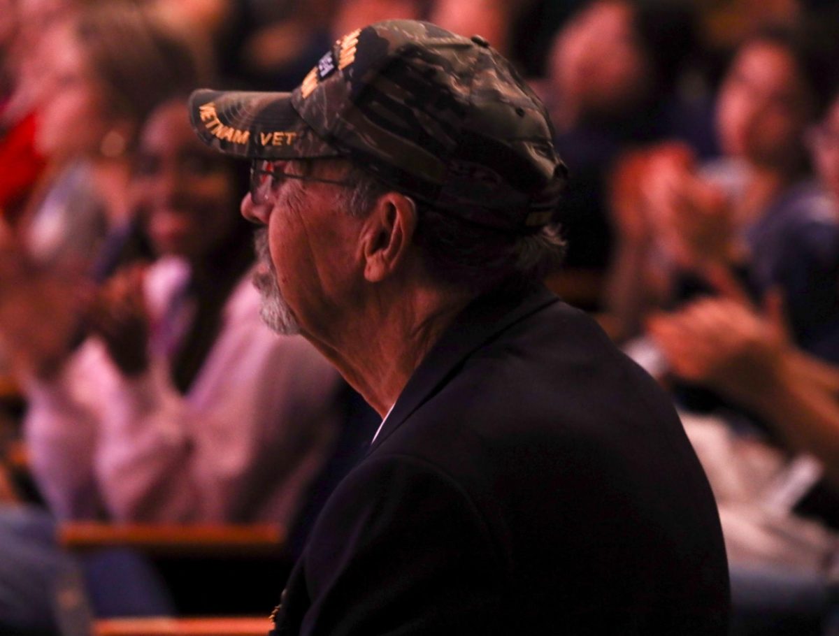 Watching from the audience, doctor and veteran Ron Rising listens to the music as the Dreyfoos band plays in his honor and in honor of all those who have served.  
